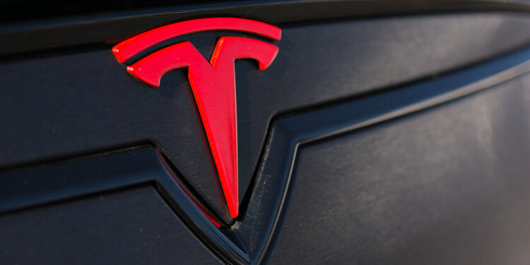 Tesla Logo Car 750x375 - Tesla plans to stock split, so it can pay a stock dividend to shareholders