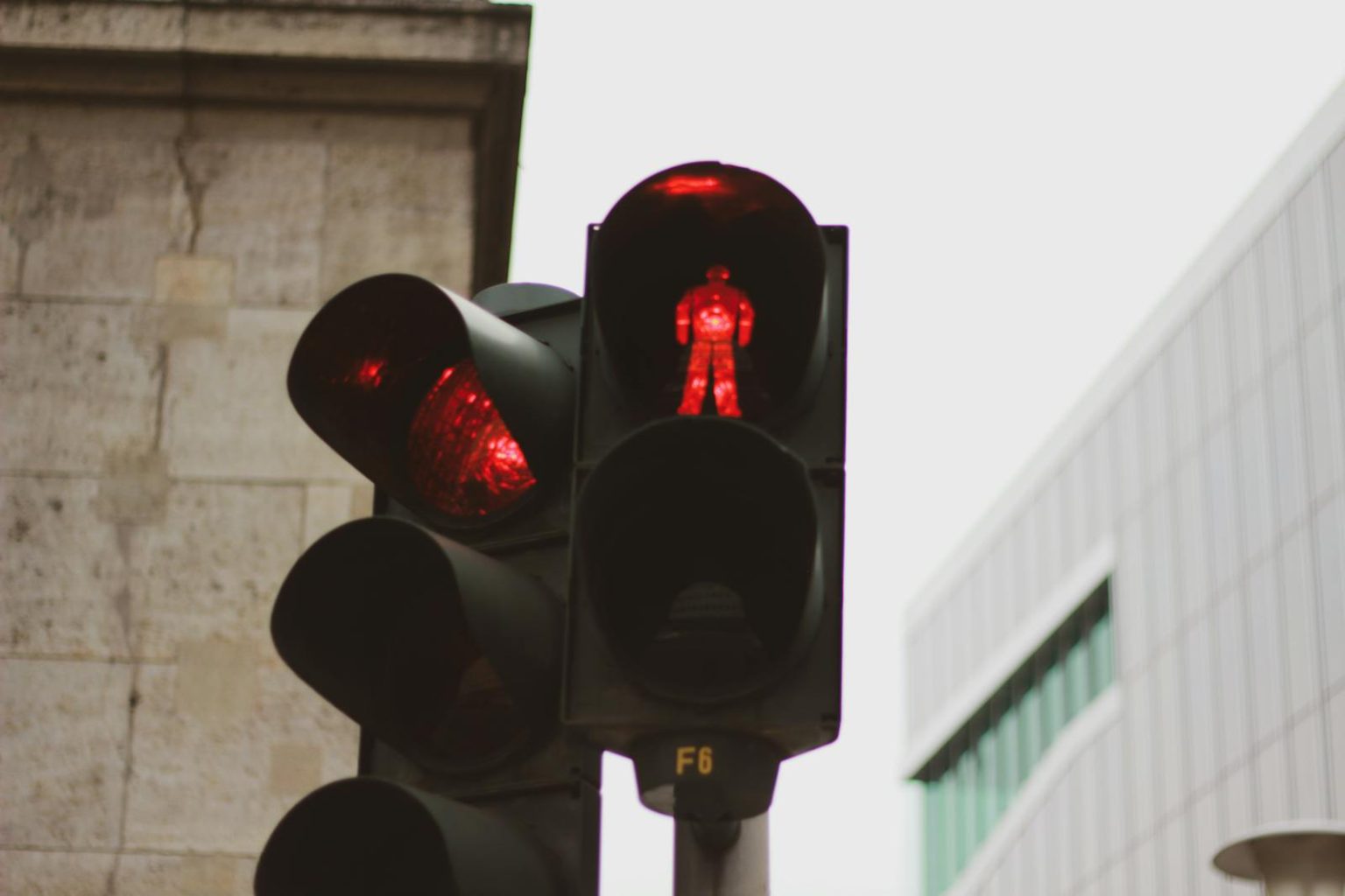 NHTSA Cites Over 80 Potential Traffic Violations Linked to Tesla FSD Software Red traffic light in Berlin with urban architecture backdrop.
