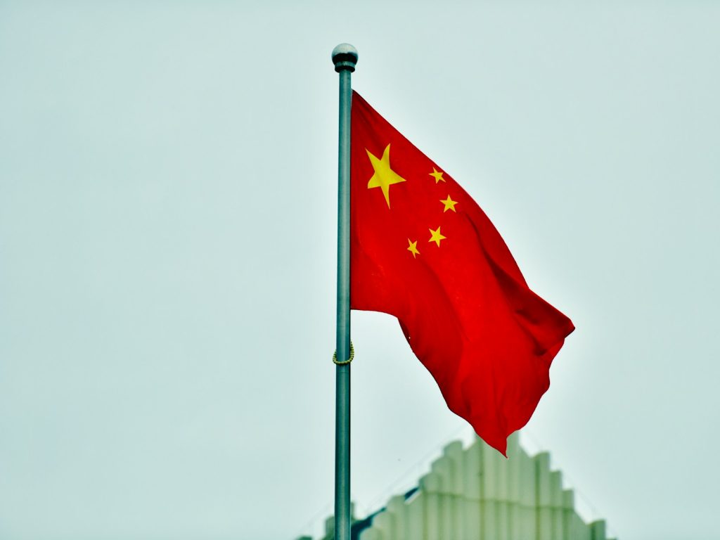 China Approves First Level 3 Autonomous Driving Permits For Passenger Cars a red and yellow flag on a pole