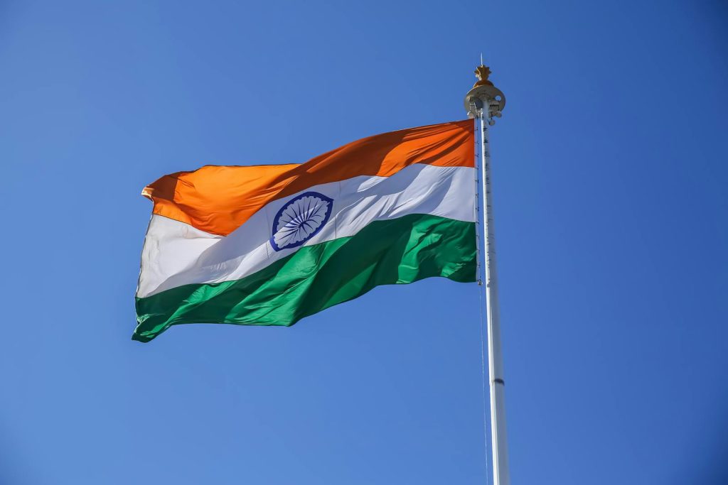 A vibrant Indian national flag waving proudly against a clear blue sky in Shimla, Himachal Pradesh.