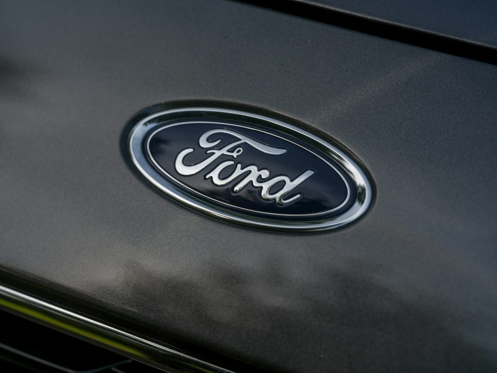 Ford Files Patent for System to Optimize EV Routing and Charging Stops The ford logo is displayed on a car.