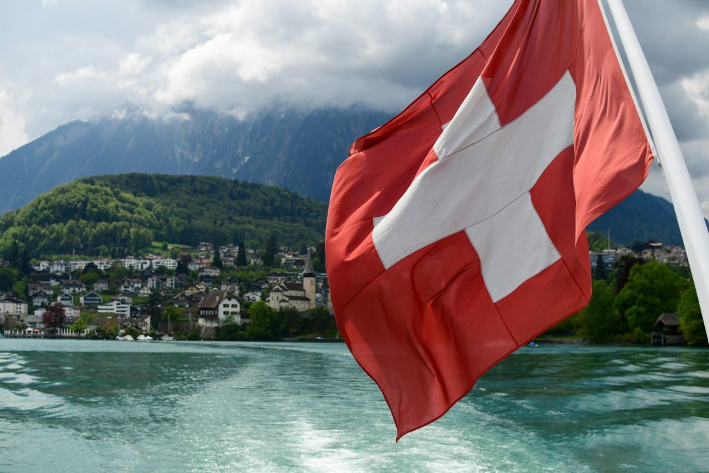 Switzerland Launches Tender for Fast-Charging Network for Electric Trucks a red and white flag flying over a body of water