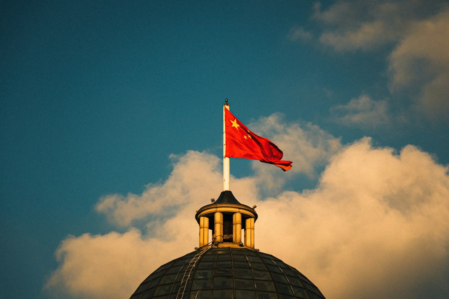 China Targets Solid-State Batteries, L3 Autonomy in Push to Boost NEV Industry a red and white flag on top of a building