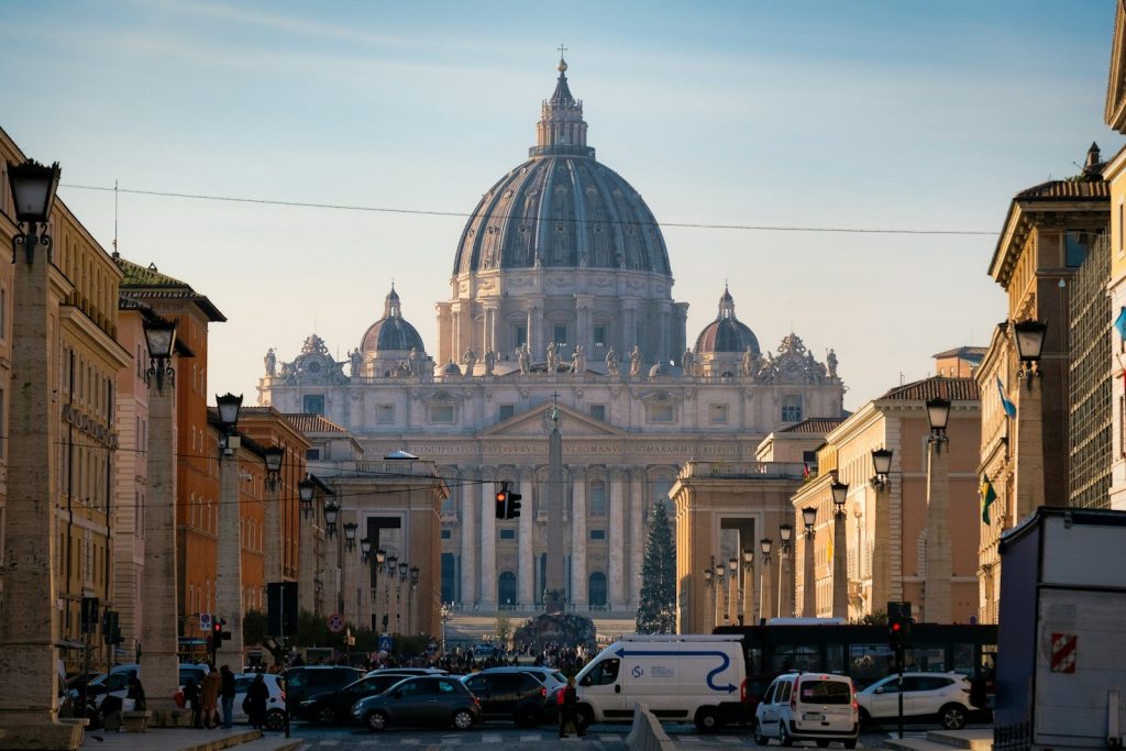 The st. peter's basilica towers above the street.