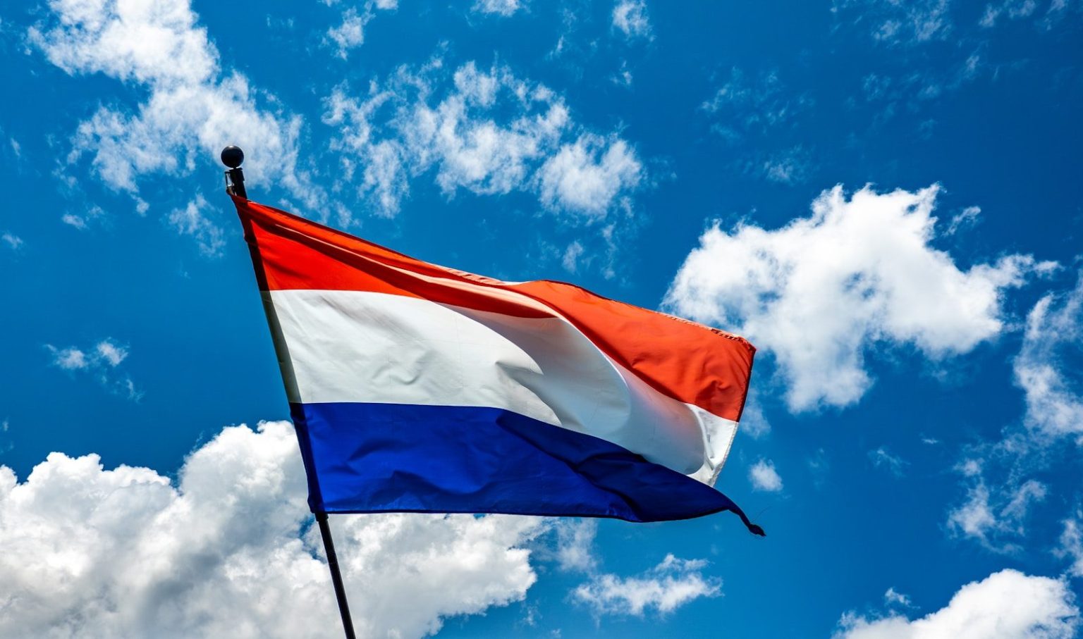 Netherlands to Increase Tax Burden on Non-Electric Company Cars From 2027 A red white and blue flag flying in the sky